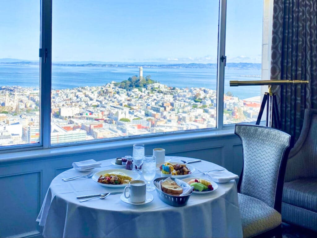 A breakfast table at the Fairmont hotel with a scenic view of San Francisco from the glass window, San Francisco itinerary