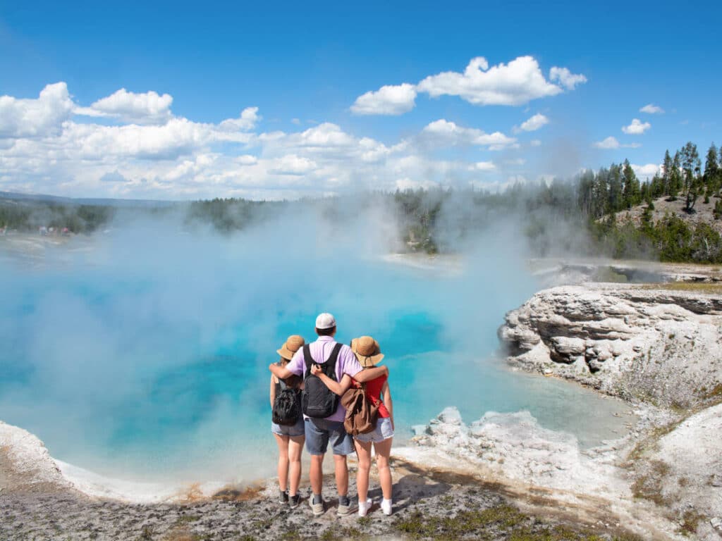 A family admiring the view in Yellowstone National Park during a road trip