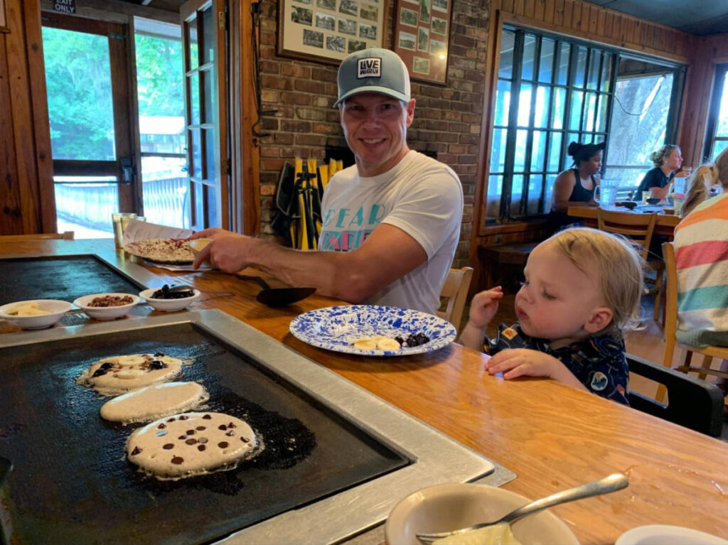 Father and son making pancakes at the table