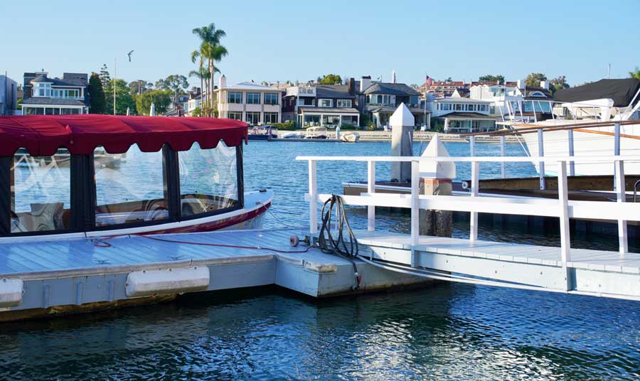 A red boat canopy on a dock used for Famous Homes Boat Tour