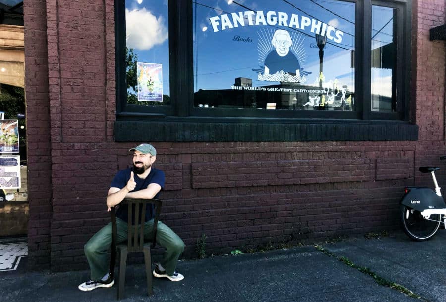 A man goofily posed outside the Fantagraphics store
