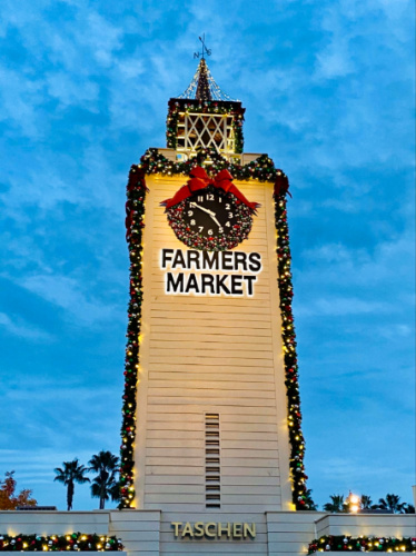 The Farmers Markets sign on a clock tower with Christmas decorations