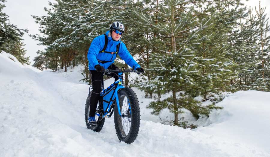 A man fat tire biking in Breckenridge while wearing his safety gears