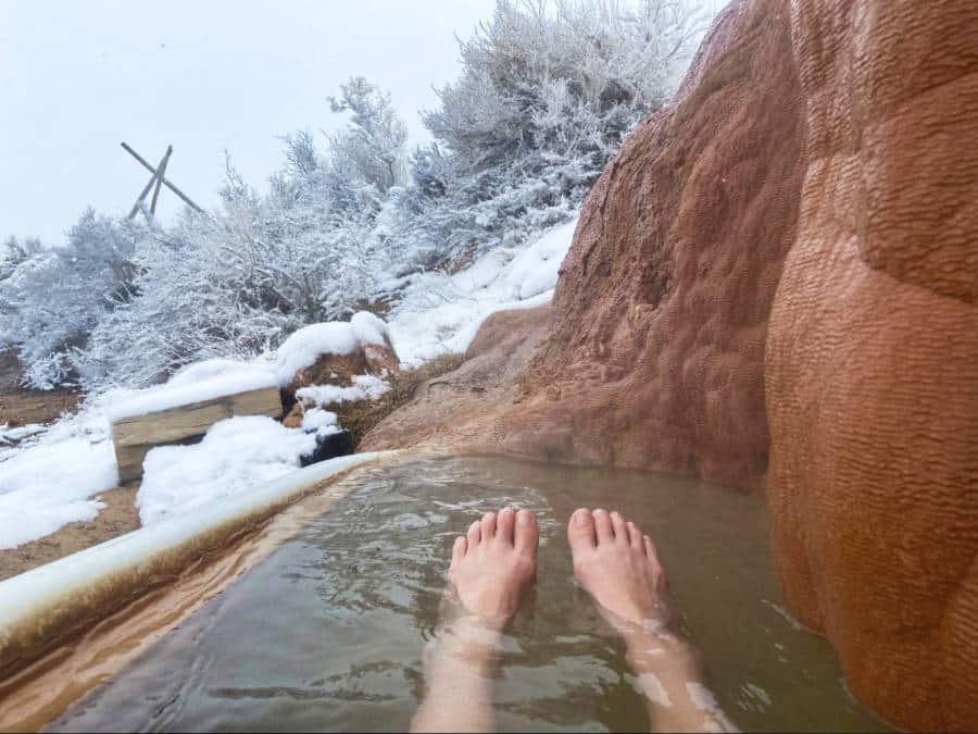 View of the feet soaking in a hot spring in Moab during winter