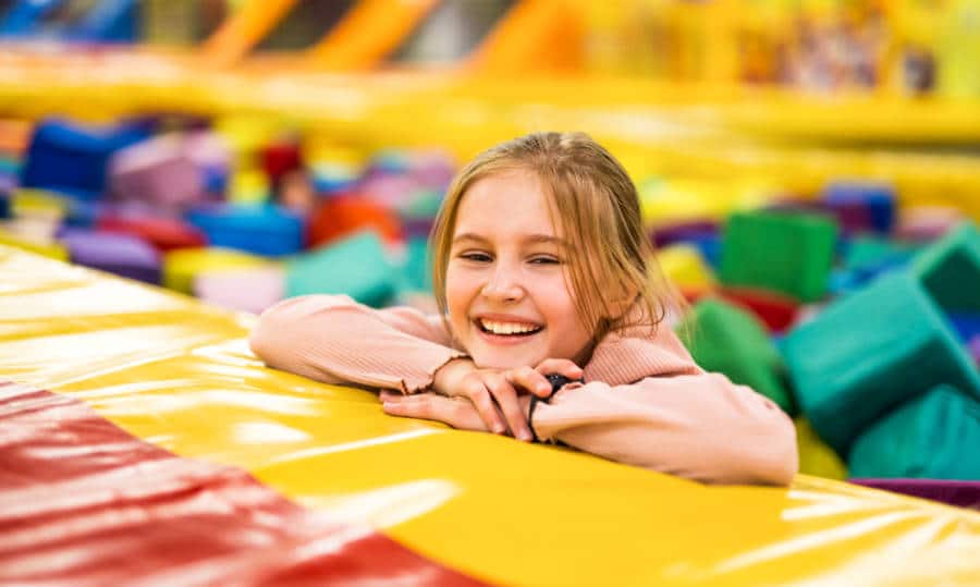 A smiling girl inside the colorful cube trampoline