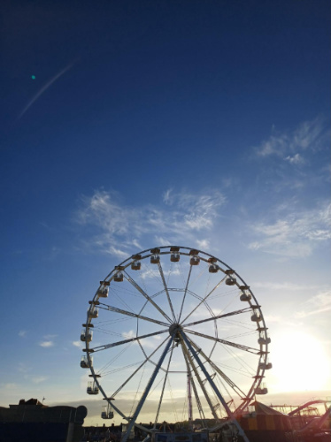 Blue sky over a ferris wheel in Wales