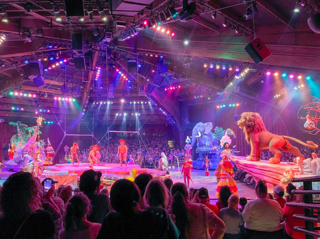 Simba and friends performing at Festival of the Lion King show, captivating a lively crowd