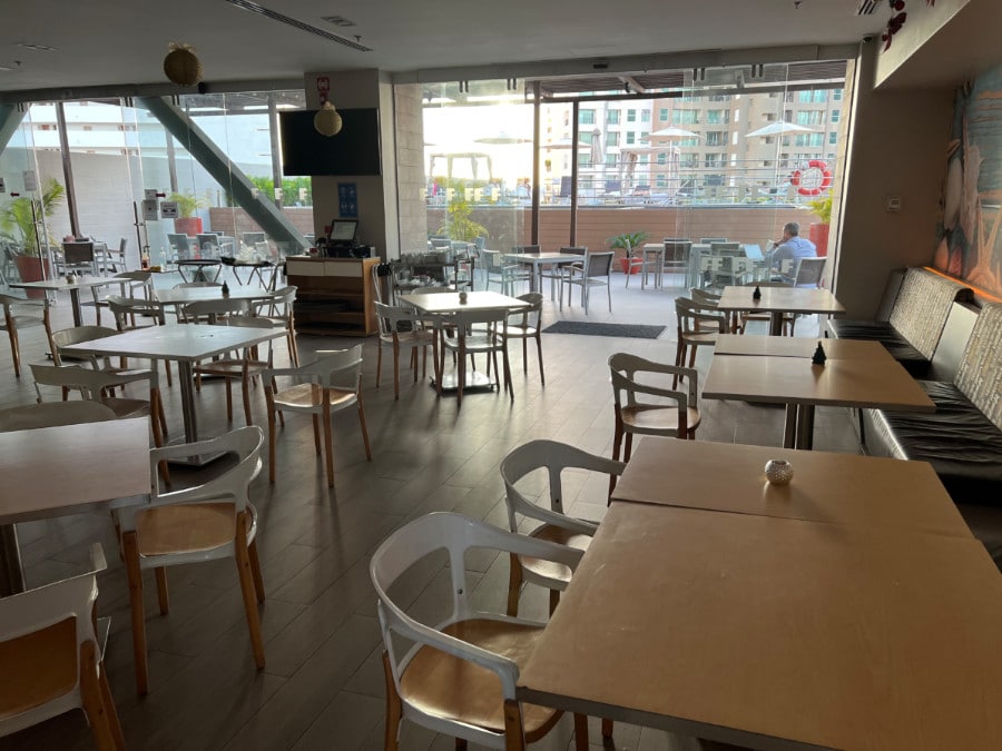 View of tables and chairs inside a dining area in Fiesta Inn La Isla Puerto Vallarta