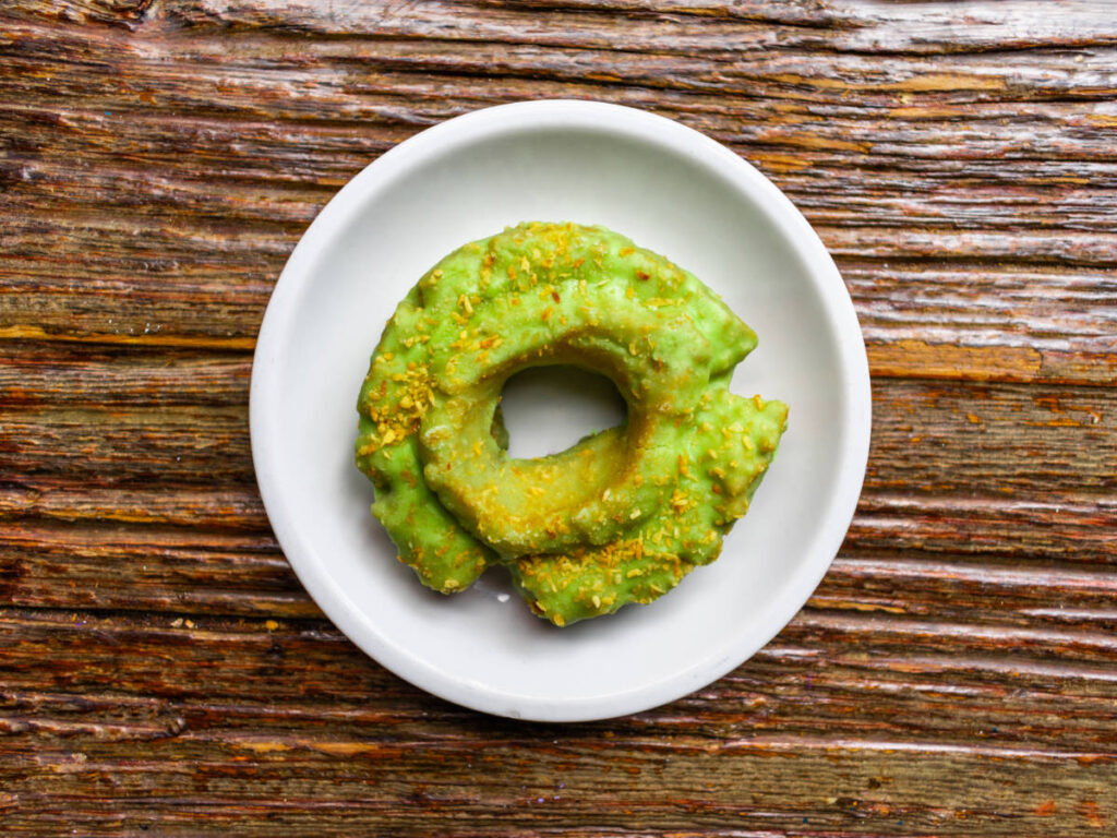 A pistachio donut on a plate from Firecakes Donuts
