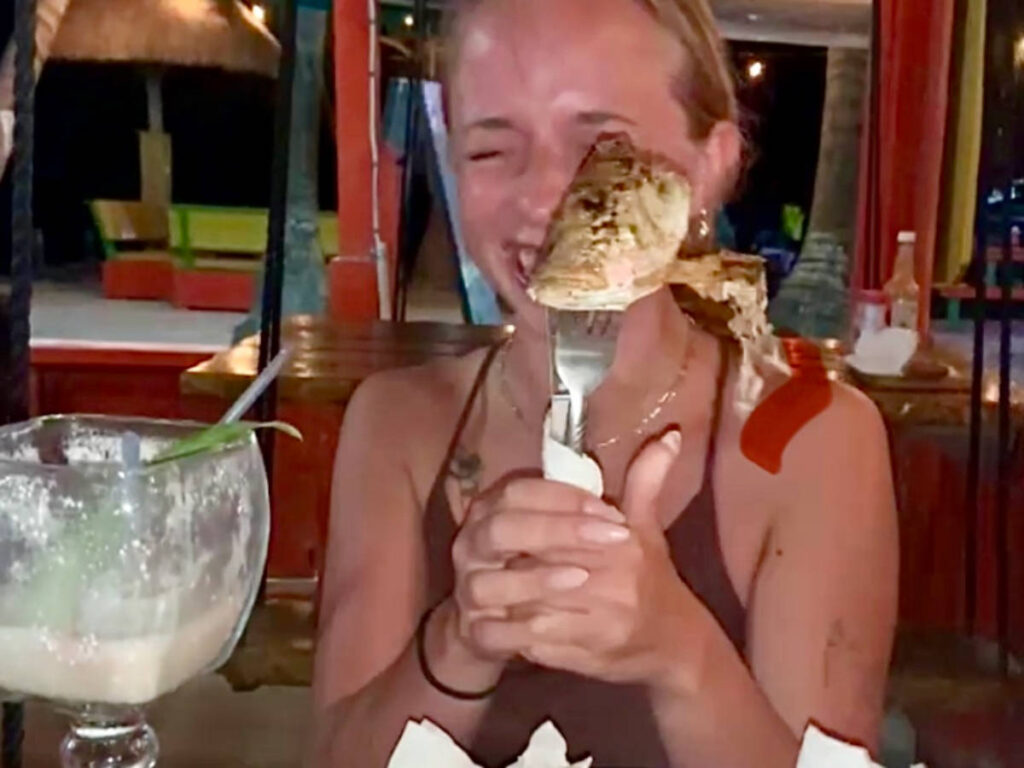 A woman holding a fork with a fish head on it