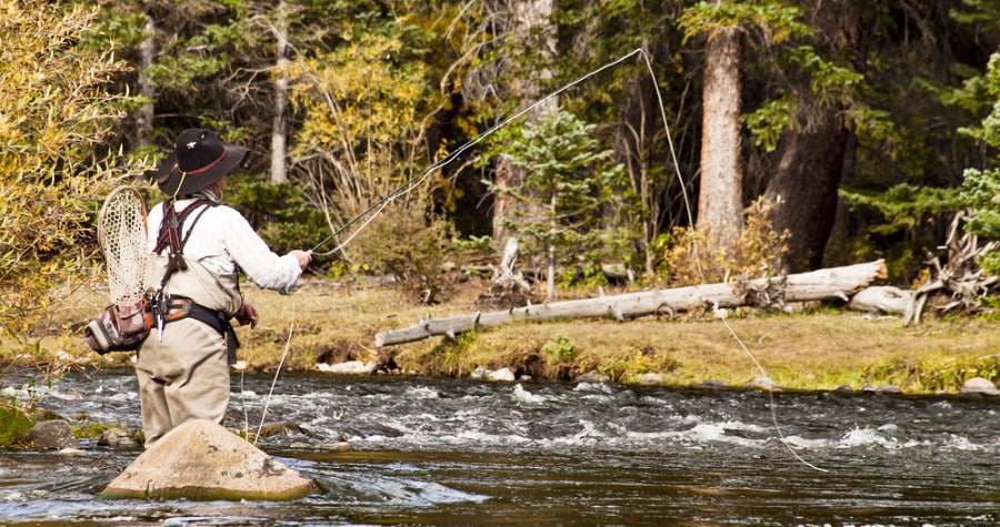 A man fishing in the middle of the river of Colorado