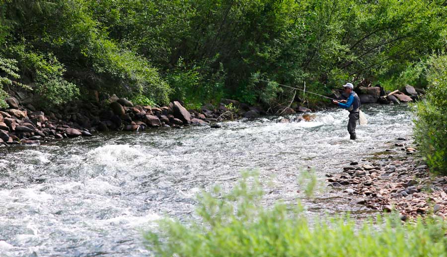 A man fishing in the Clear Creek in Idaho Springs
