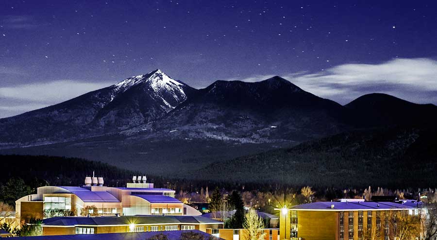 The NAU campus under the starry night and a snowy mountain on its background in Flagstaff