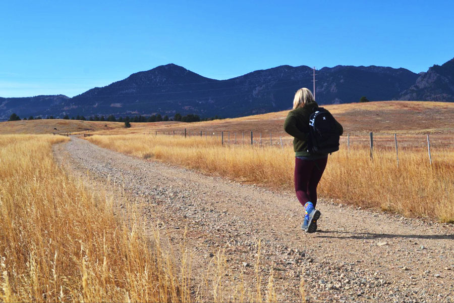 View of a woman walking to Flatirons Vista Trail