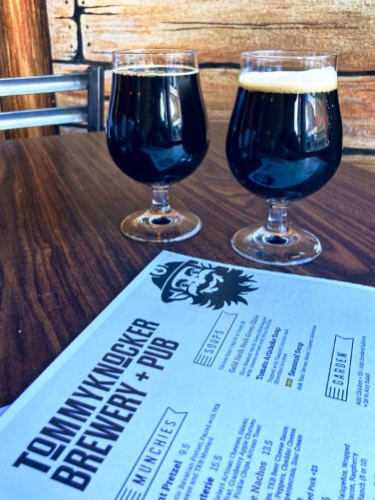 Two glasses of beer and a menu on a wooden table