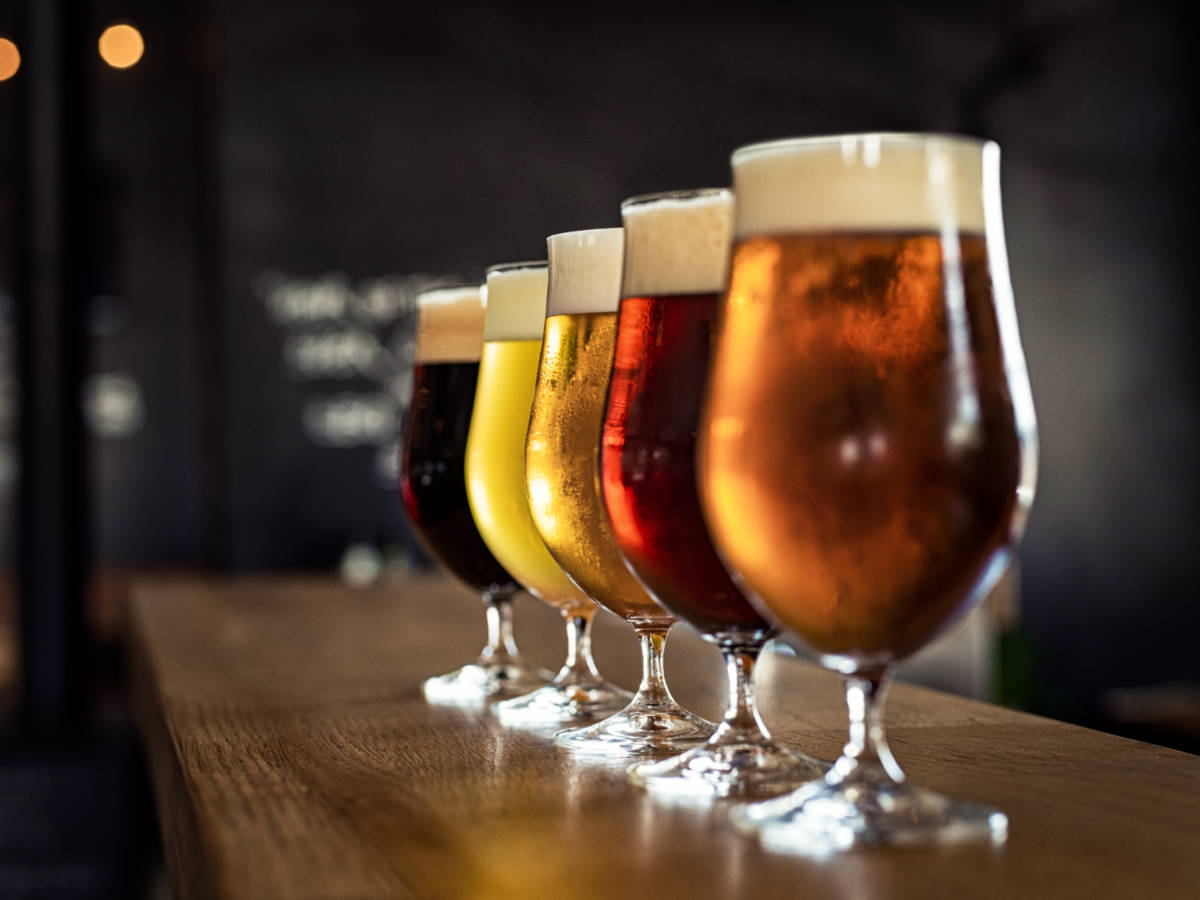 A flight of variety of beers on the wooden table