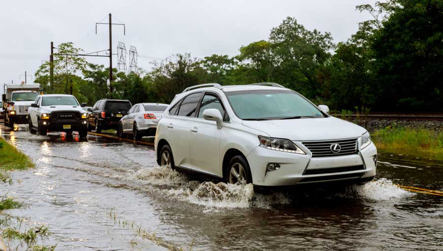 Cars driving through a road with flood water