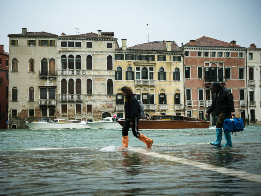 The people walking on the flooded street of Venice