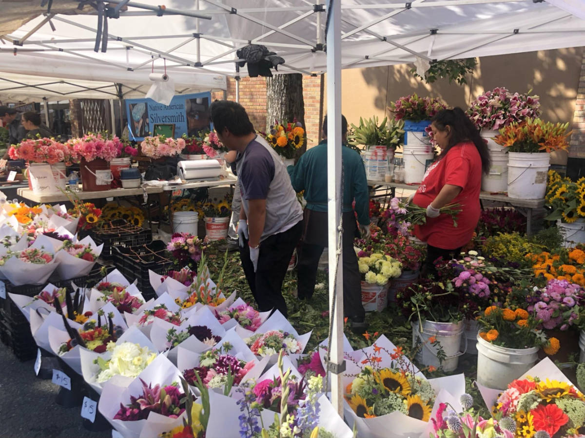 People preparing at the flower shop at Ballard Farmers Market