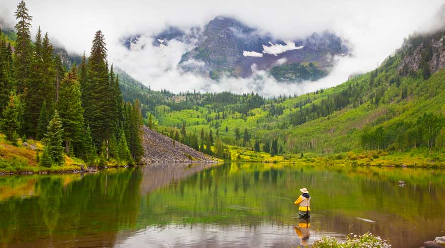 A man fly fishing in the Maroon Bells