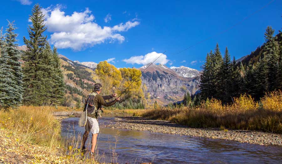 A fly fisher under the clear blue sky in San Miguel River