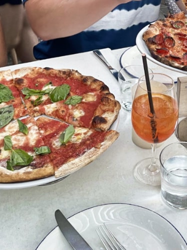 A table with plates of pizza and drink from Pizzeria Portofino
