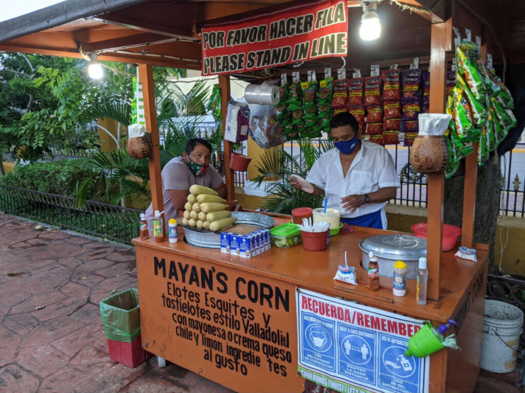 The vendors of the elotes and esquites on the food stand