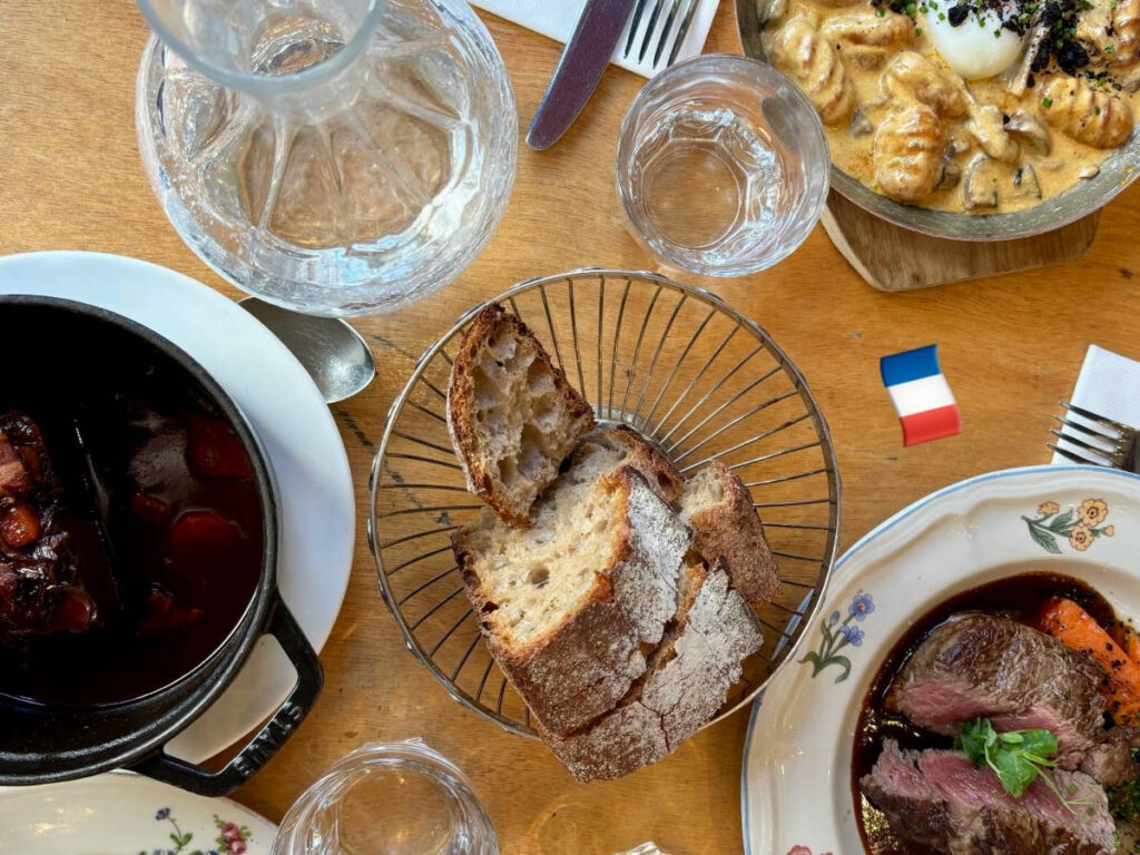 A table full of a variety of foods including beef bourguignon in Café des Musées
