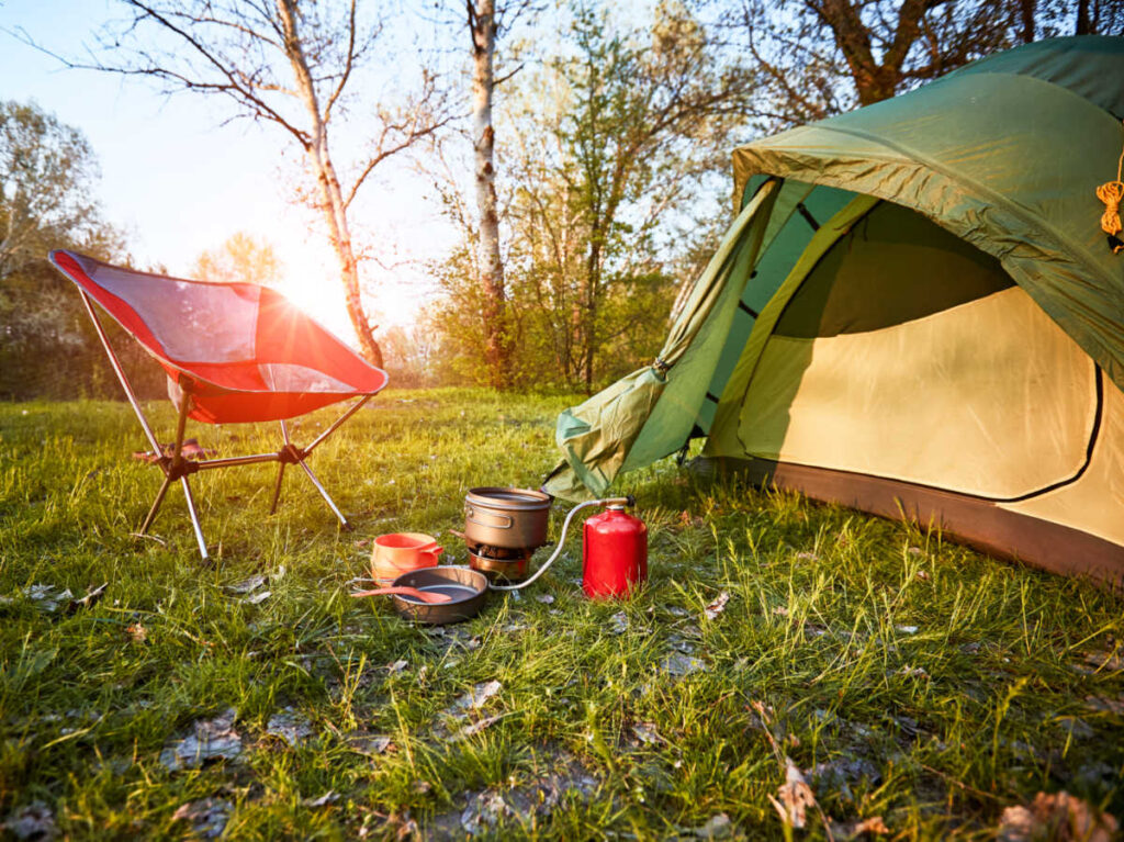 A camping tent and setup in the forest at sunrise