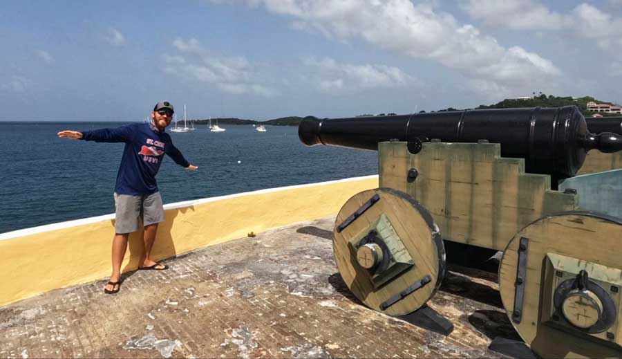 The author posing for a photo with a canon in Fort Christiansvaern