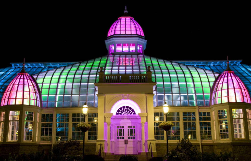 The Franklin Park Conservatory and Botanical Gardens at night with colorful lights