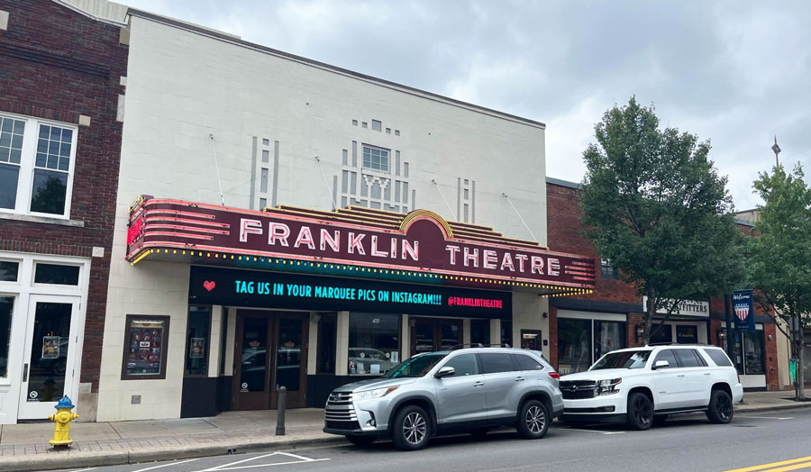 Cars park in front of the Franklin Theatre building
