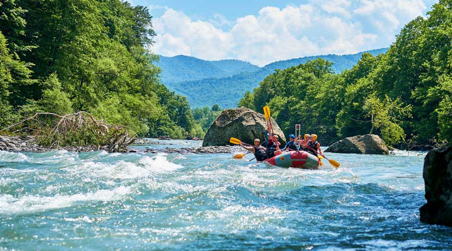 People whitewater rafting in French Broad Adventures