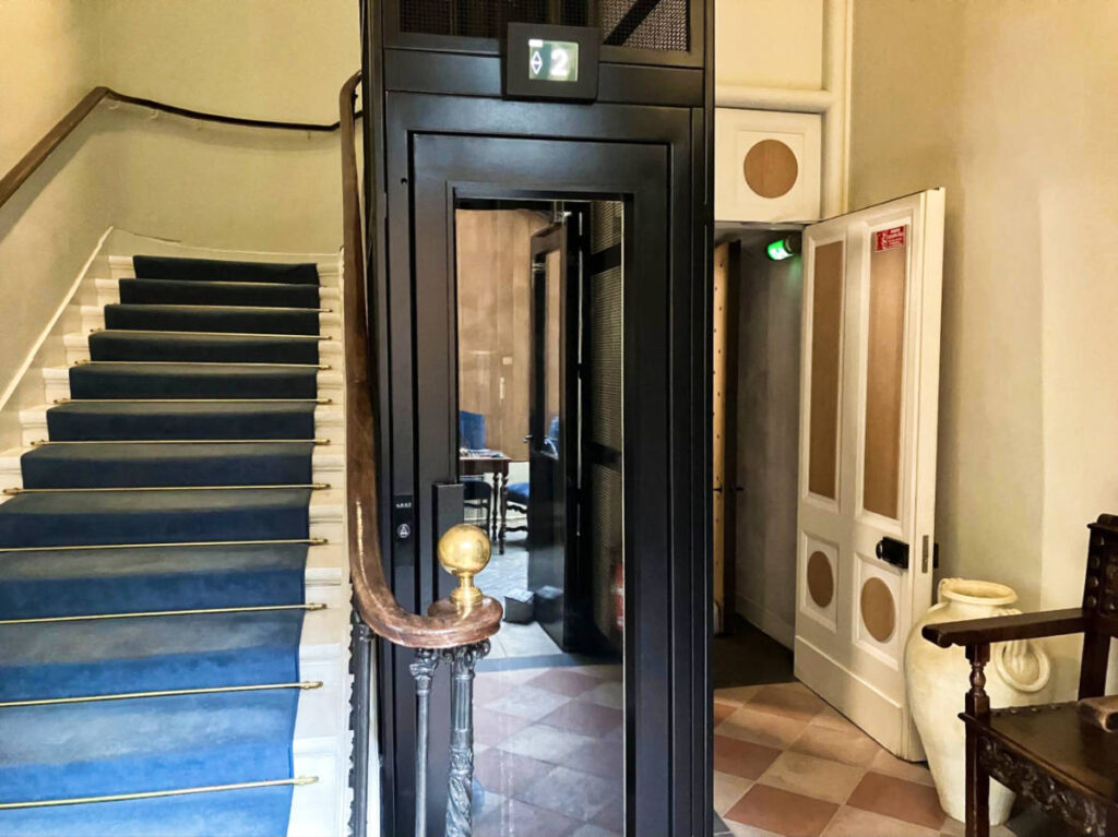A narrow French elevator near the staircase