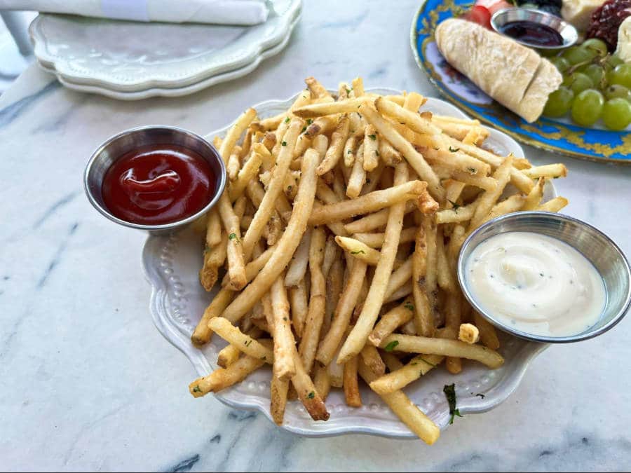 A plate of fries with dipping sauces on the side