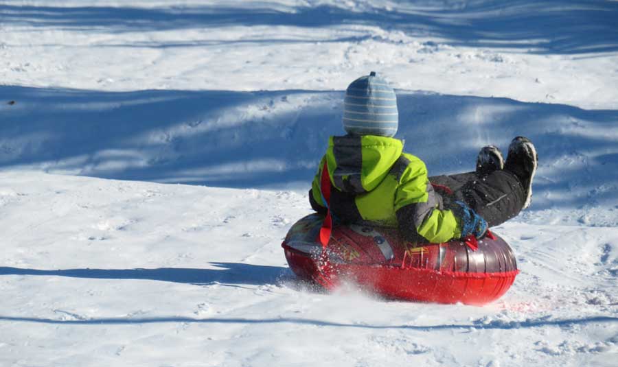 View of a child having fun in a snow tube