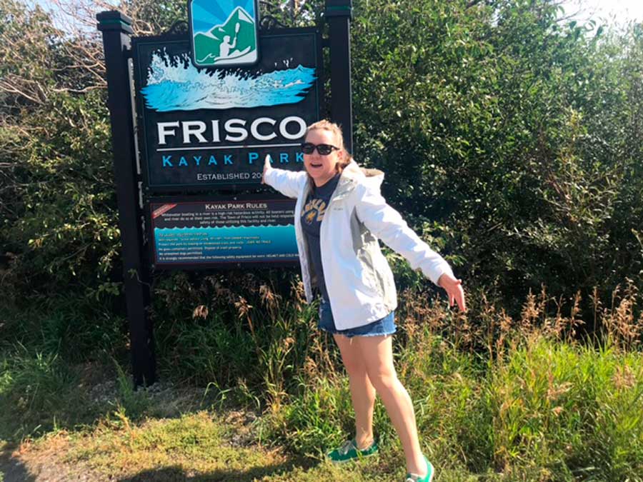 The author posing for a photo beside the Frisco Kayak Park sign