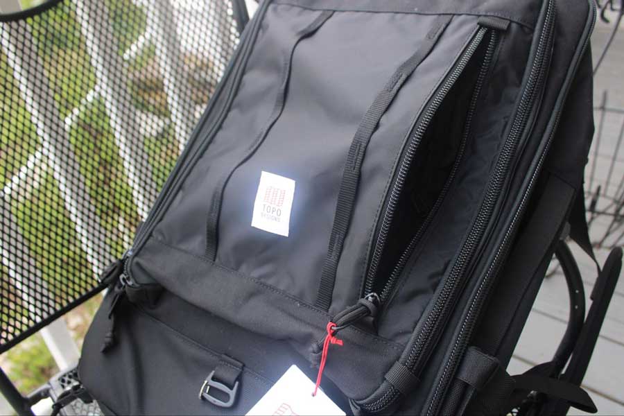 View of the open front zippered pocket of Topo Bag