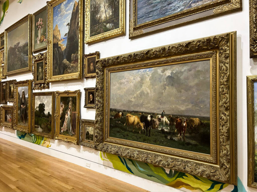 A wall full of framed paintings inside the Frye Art Museum
