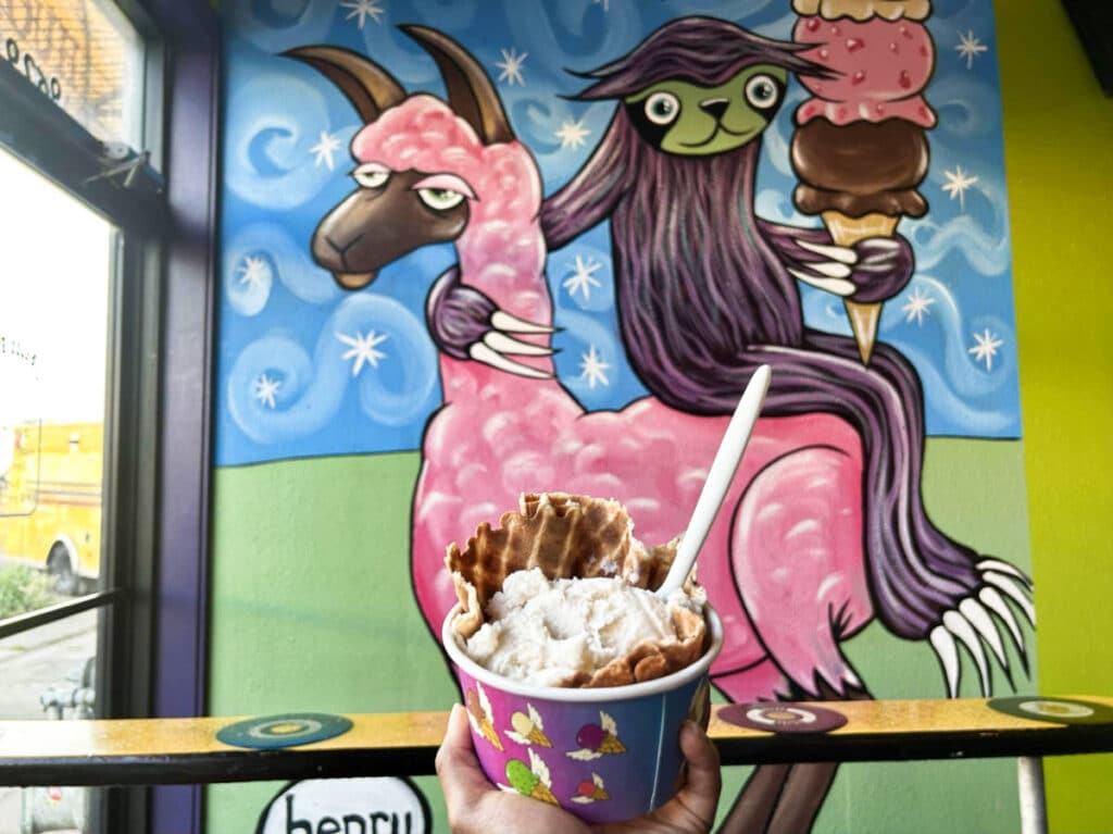 A cup of ice cream and a funky art in the wall at Full Tilt Ice Cream