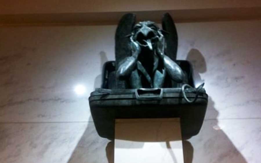 A gargoyles perched in suitcase statue at the Denver International Airport
