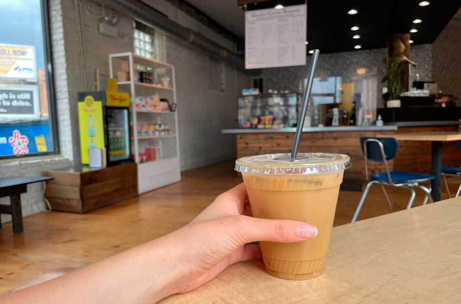 The author holding her lavender iced latte in Gaslight Coffee Roasters