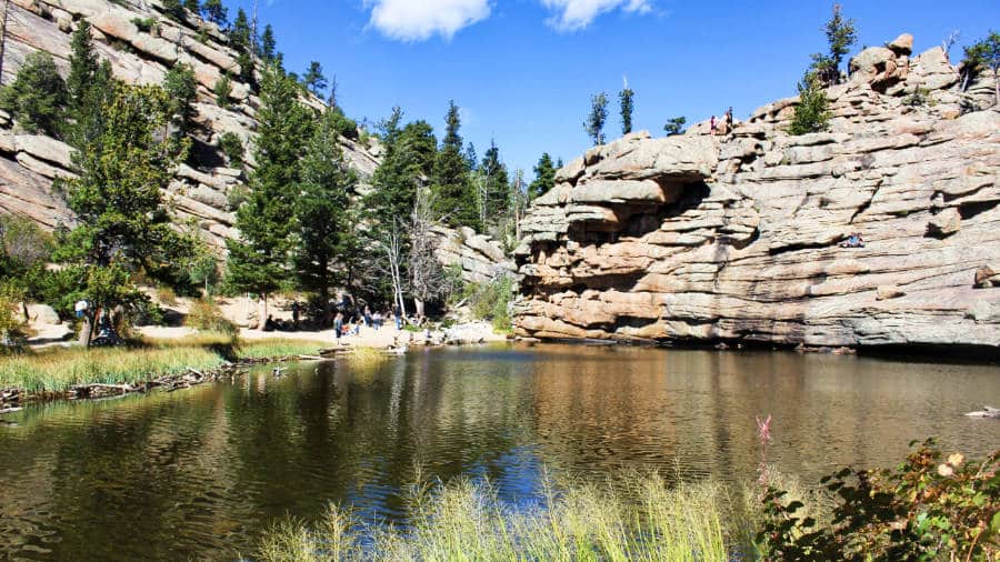 View of the clam water of Gem Lake and the rocky mountain in the background