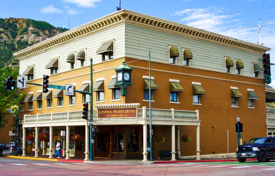 Exterior view of the vibrant yellow and white building of General Palmer Hotel