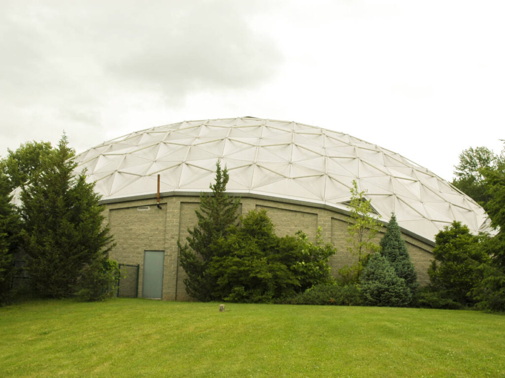 View of the top of geodesic dome and lush landscape at Dinosaur State Park