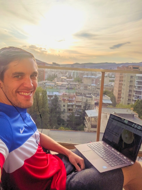 Nate with a laptop on apartment terrace in Tbilisi 