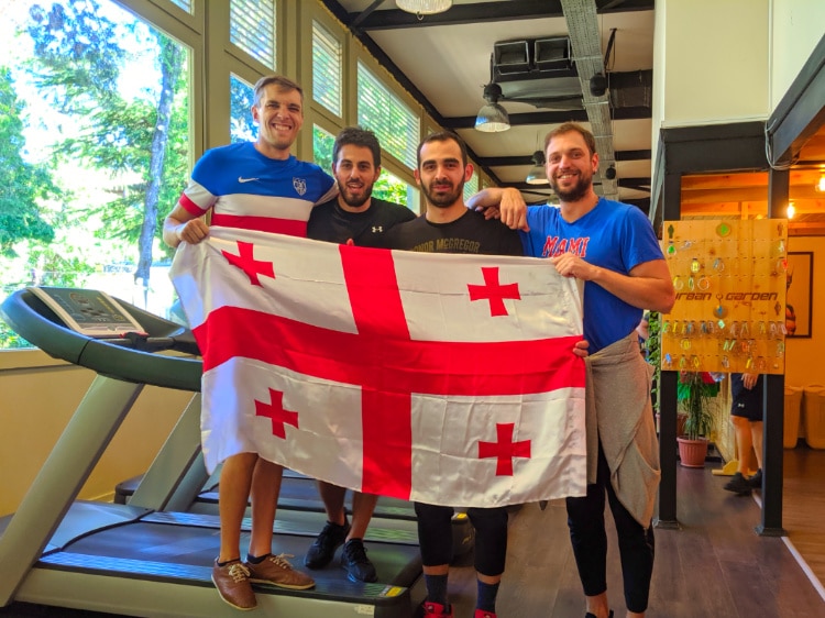 Georgia flag held by Nate and his trainers at a gym