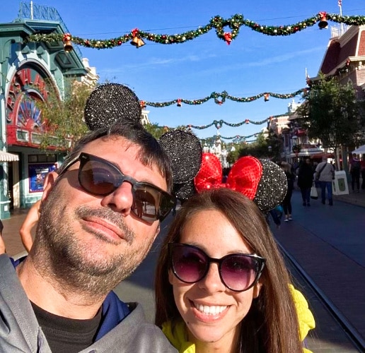 A closeup photo of the author McKenna Mobley and a man posing on the main street during the Christmas season