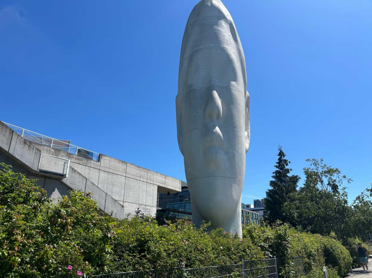A giant head sculpture surrounded by greenery