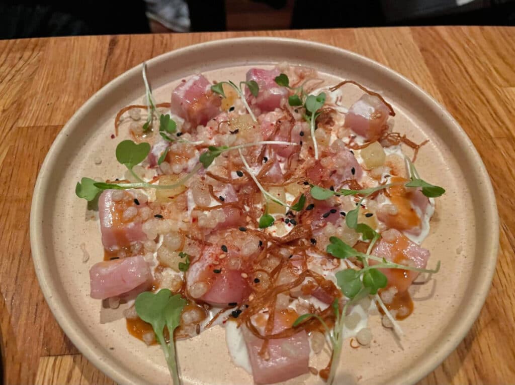 A plate of hamachi crudo served in Girl and the Goat
